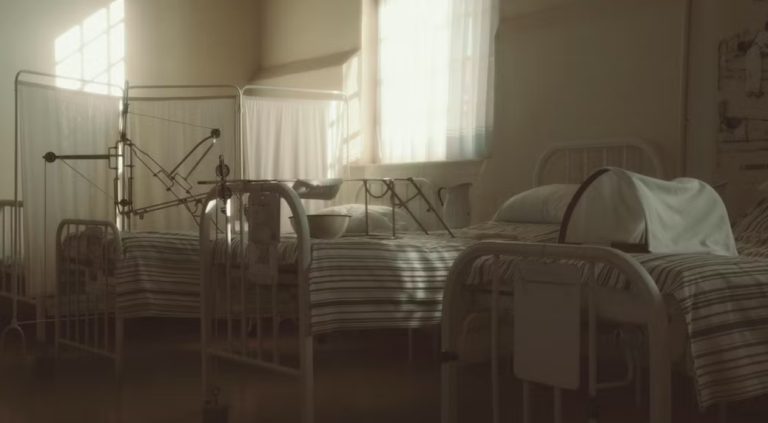 줄무늬 이불과 구형 장비가 놓인 병동 내부